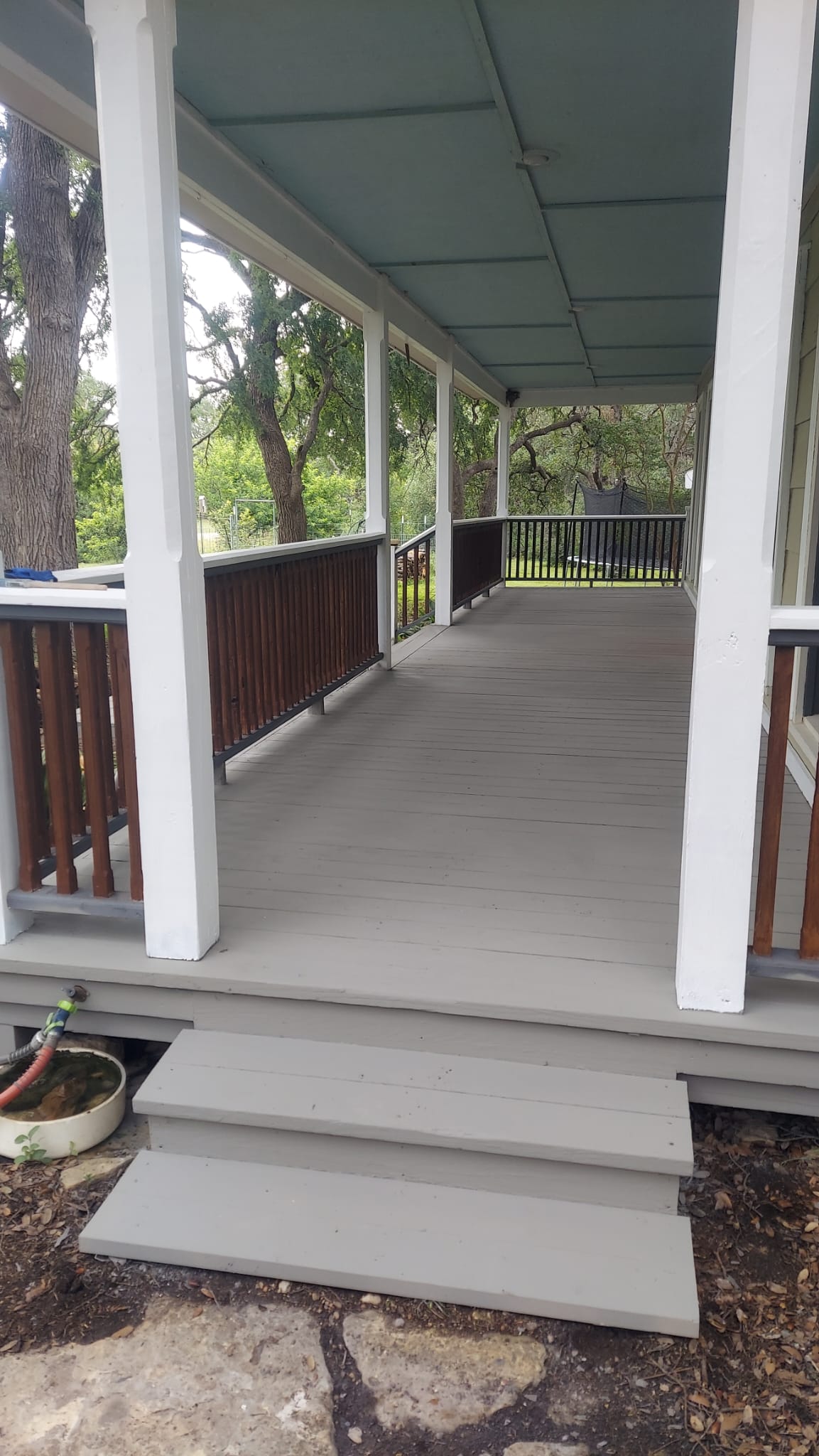 Covered deck with wood railing built by Risen Remodeling in New Braunfels TX