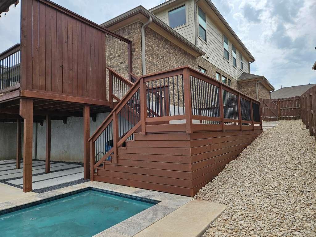 Elevated wood deck with stairs and pool by Risen Remodeling in New Braunfels TX