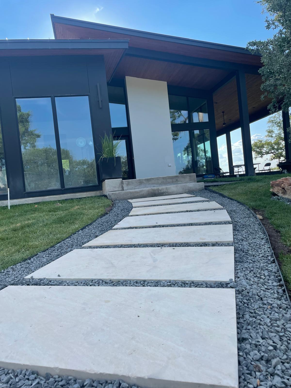 Modern concrete walkway and landscaping by Risen Remodeling in New Braunfels TX